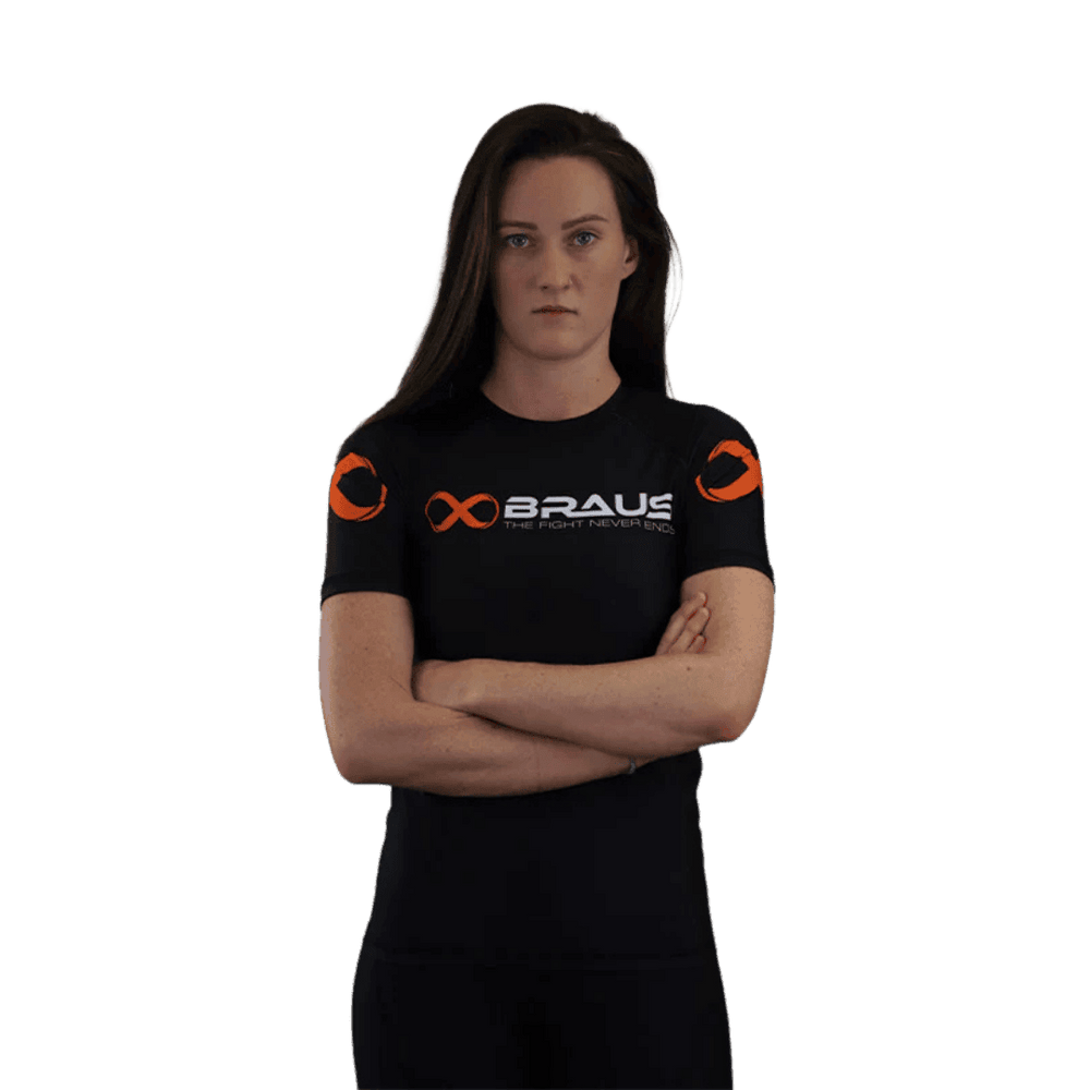 Een afbeelding van de voorkant van een zwart damesrashguard met korte mouwen van Braus. Het shirt heeft een opvallend oranje logo en de tekst "Braus - The Fight Never Ends."
