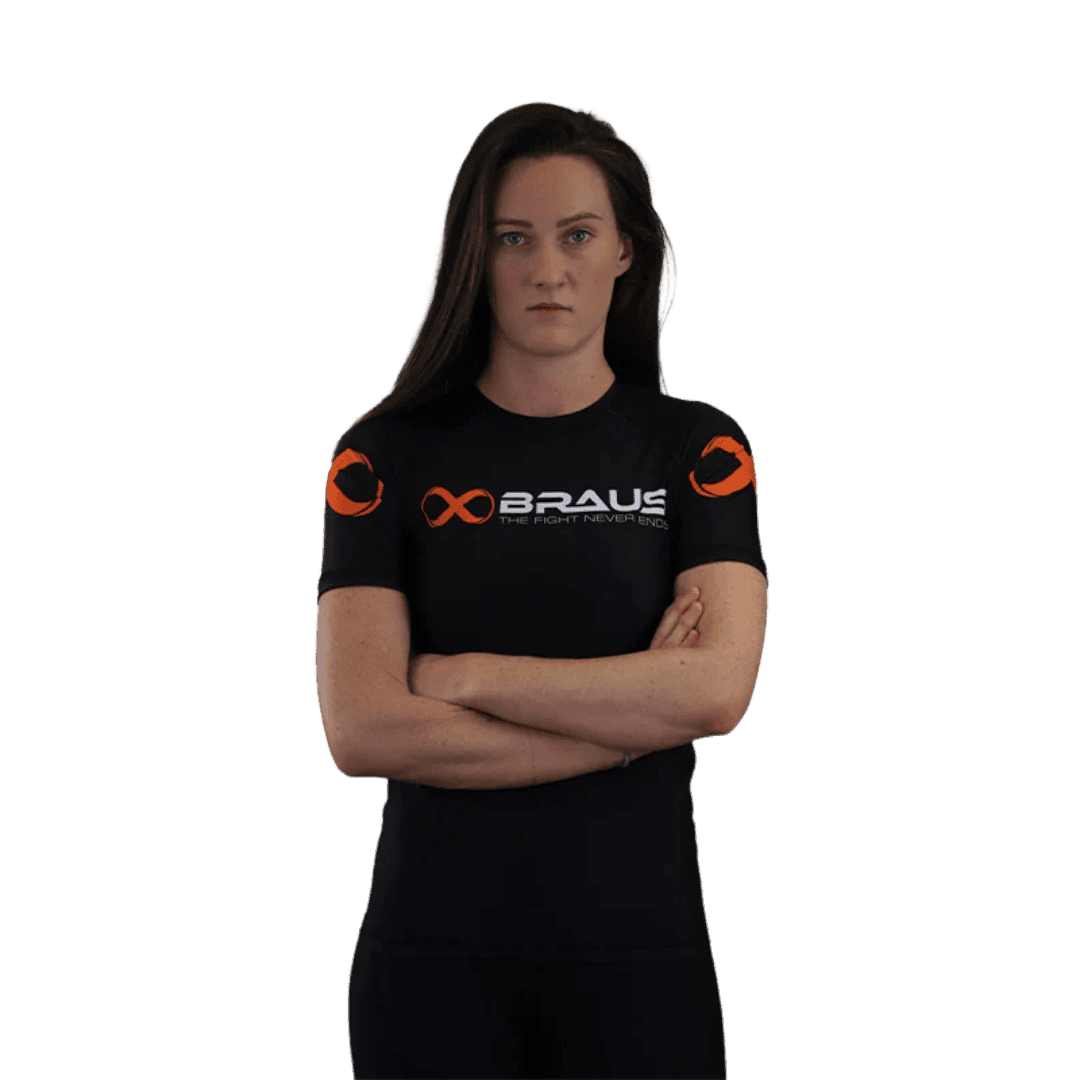 Een afbeelding van de voorkant van een zwart damesrashguard met korte mouwen van Braus. Het shirt heeft een opvallend oranje logo en de tekst "Braus - The Fight Never Ends."