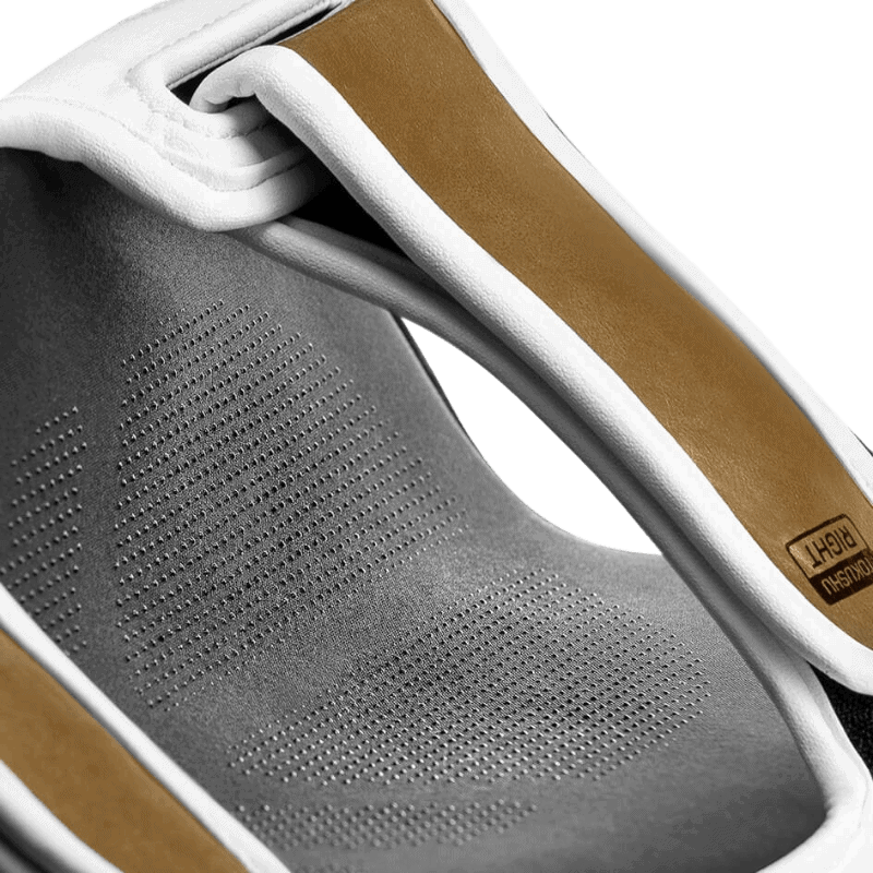 Detailopname van de binnenkant van de Hayabusa T3 Striking Scheenbeschermer in wit en goud, met aandacht voor het ademende materiaal en de kwaliteit van de voering.