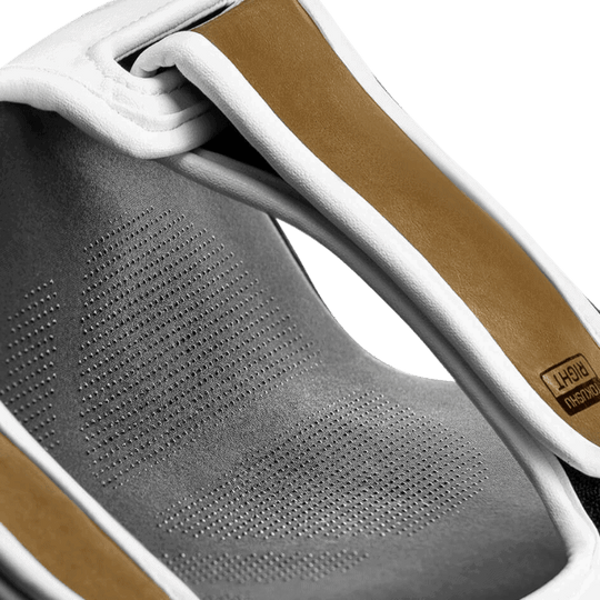 Detailopname van de binnenkant van de Hayabusa T3 Striking Scheenbeschermer in wit en goud, met aandacht voor het ademende materiaal en de kwaliteit van de voering.