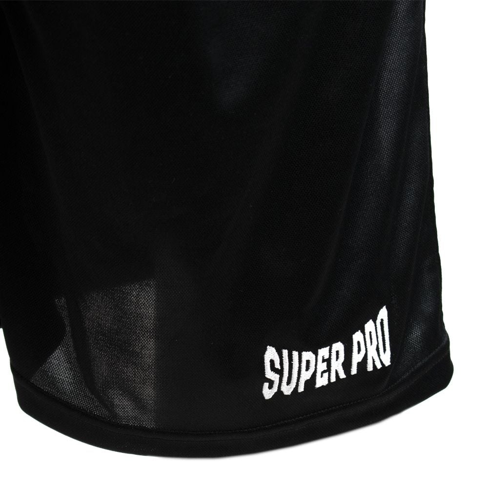 Close-up van de linkeronderkant van de zwarte Super Pro boksshort, met het merklogo "Super Pro" in witte letters op de zoom.