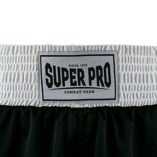 Close-up van de brede witte elastische tailleband van de zwarte Super Pro boksshort, waarop een zwart-wit Super Pro-logo duidelijk zichtbaar is.