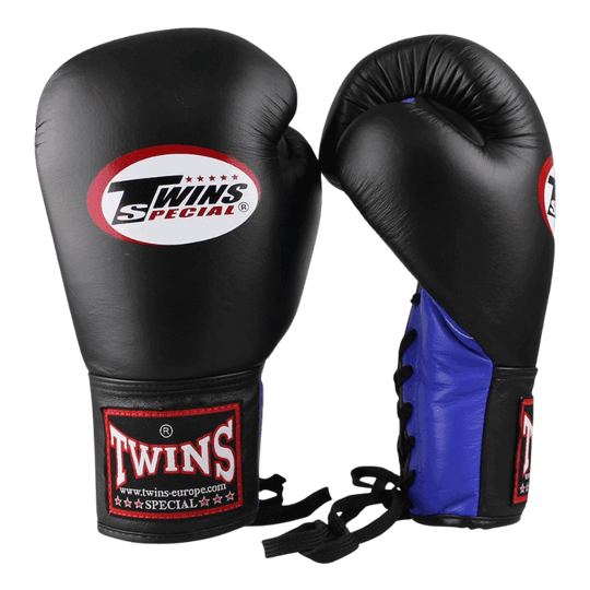 Paar Twins bokshandschoenen BGLL 1 in het blauw met zwarte padding aan de binnenkant en logo op de klittenbandsluiting, liggend op een zwarte achtergrond.