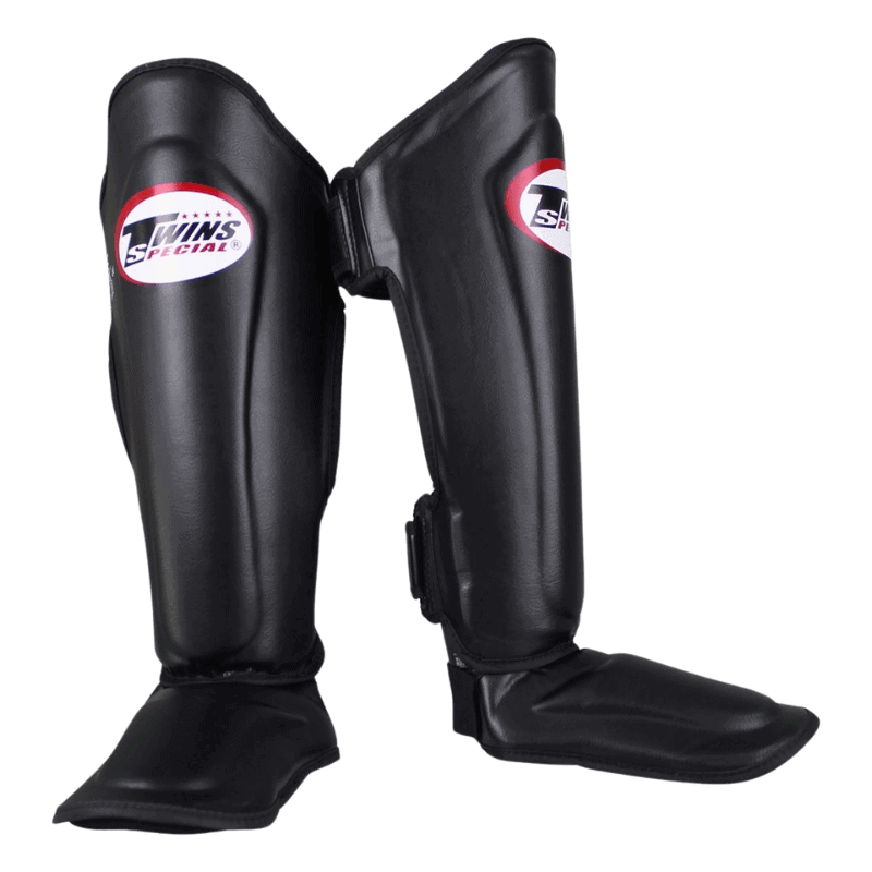 Twee Twins SGL 7 scheenbeschermers in het zwart, zij aan zij geplaatst met de merklogo's zichtbaar.