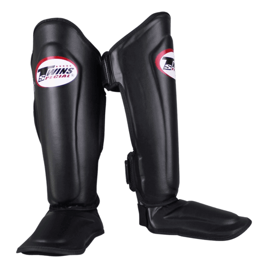 Twee Twins SGL 7 scheenbeschermers in het zwart, zij aan zij geplaatst met de merklogo's zichtbaar.