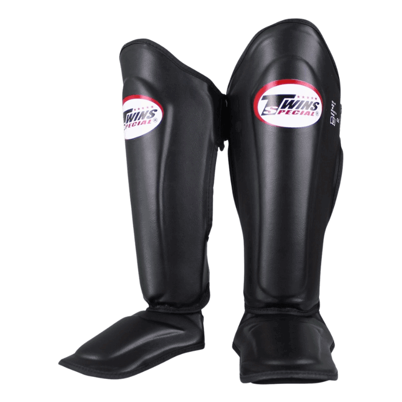 Paar Twins SGL 7 scheenbeschermers in het zwart, met het logo duidelijk zichtbaar op de voorkant van elke beschermer.