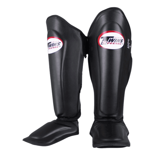 Paar Twins SGL 7 scheenbeschermers in het zwart, met het logo duidelijk zichtbaar op de voorkant van elke beschermer.