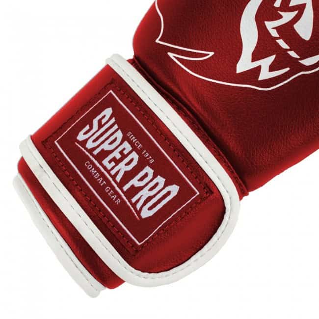 Close-up van rode kinder kickbokshandschoen met witte bies en Super Pro logo op klittenbandsluiting.