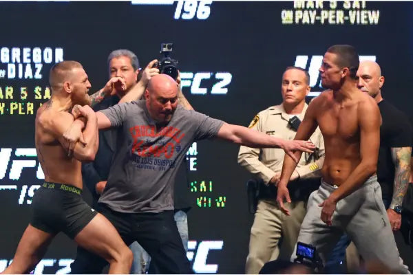 Twee vechters die tijdens een staredown uit elkaar worden gehouden door officials.