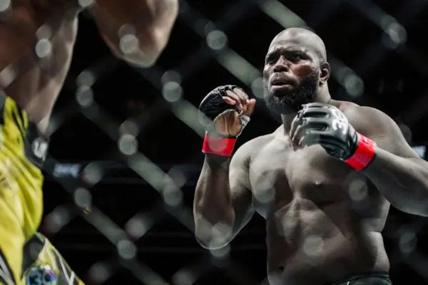 Vechter in ring kijkt uitdagend naar tegenstander, toont intimidatie en focus.