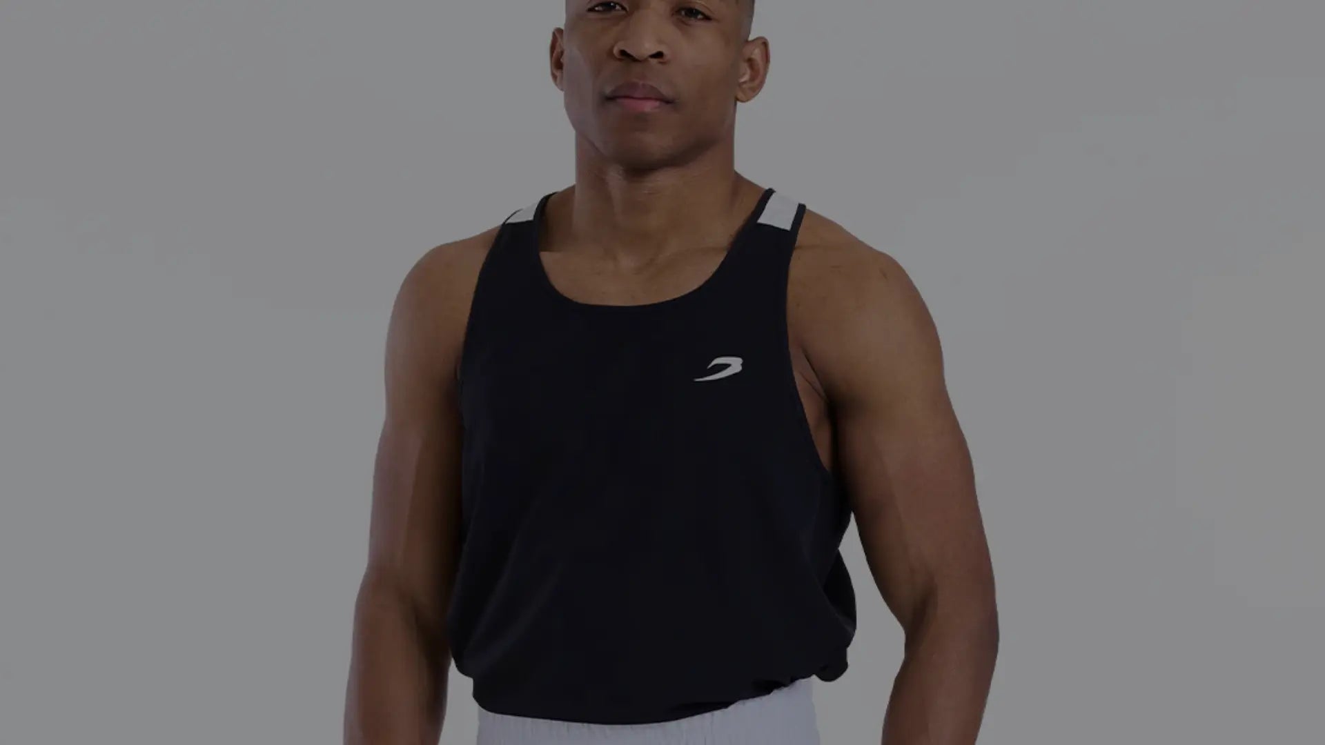 Een atleet draagt een zwart boksshirt met wit logo, staand in neutrale pose voor productpresentatie.