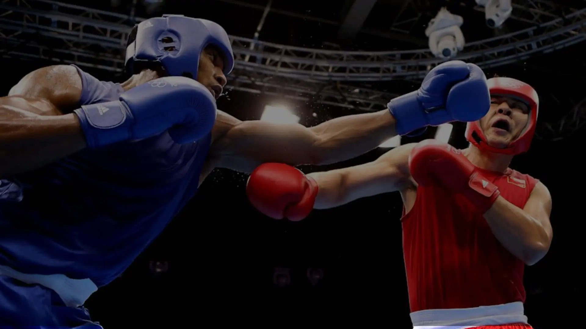 Twee boksers in een intens gevecht; de blauwe hoek deelt een rechtse stoot uit terwijl de rode hoek verdedigt, beiden met hoofdbescherming en wedstrijdboxhandschoenen.