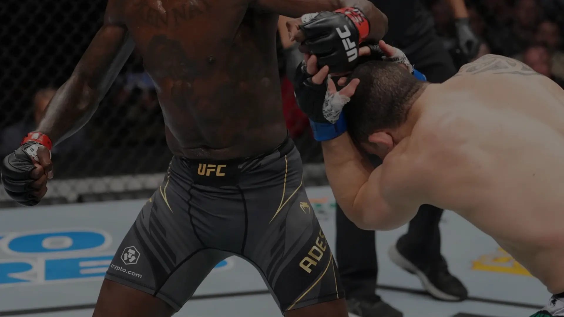 Twee UFC-vechters in actie in de octagon, waarbij één atleet in compressieshorts een aanval inzet terwijl de ander dekking zoekt.