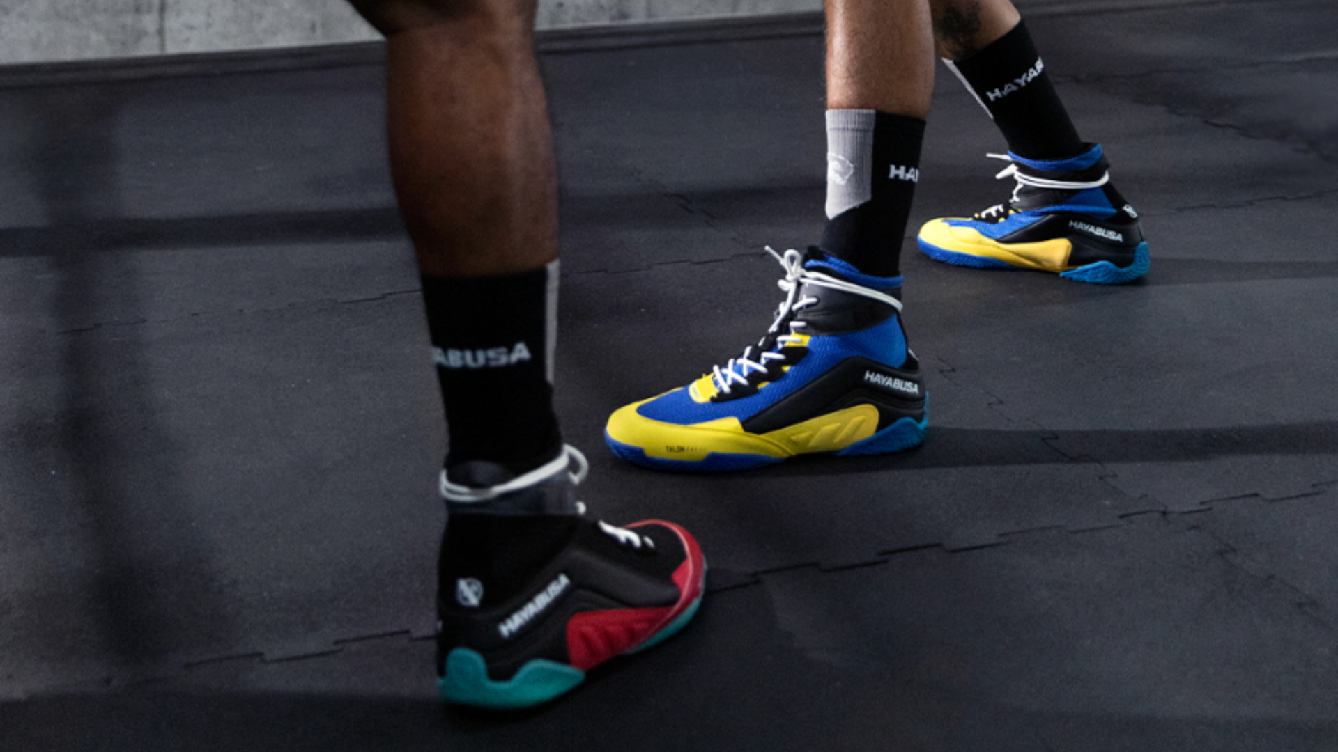 Close-up van rode Hayabusa boksschoenen gedragen tijdens een training, met gripvaste zolen en witte sportsokken zichtbaar.