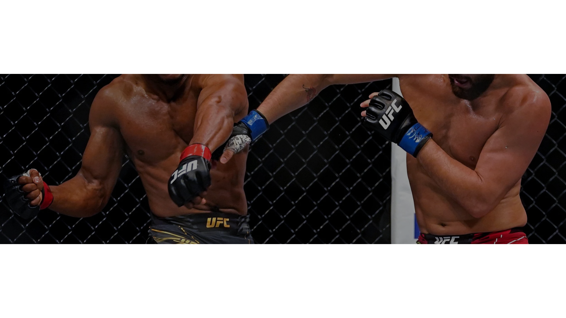 Een gespierde vechtsporter met gekruiste rode bokshandschoenen voor de borst in een donkere omgeving.