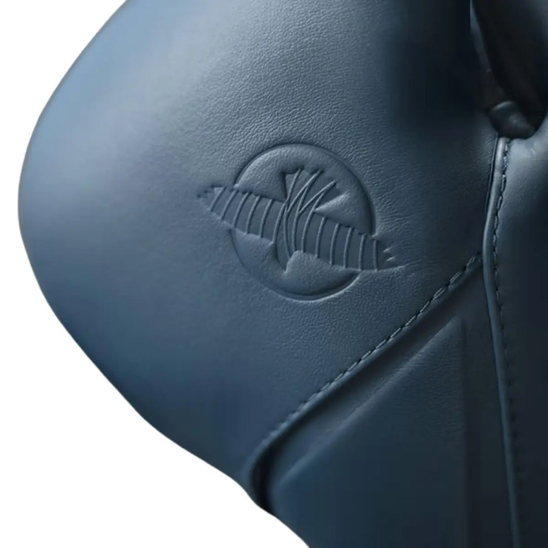 Detailfoto van een bokshandschoen in een diepe, matte blauwtint met een strak en modern design. Het subtiele reliëflogo in dezelfde kleur zorgt voor een minimalistische en stijlvolle uitstraling. De fijne textuur van het materiaal en de nauwkeurige stiknaden benadrukken de hoogwaardige kwaliteit en duurzame afwerking van de handschoen.