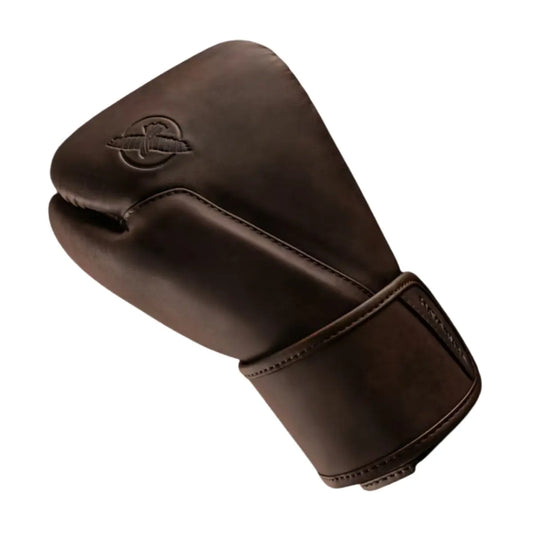 Zijaanzicht van een bokshandschoen in een diepe, warme bruintint met een matte, luxe uitstraling. Het subtiele reliëflogo in dezelfde kleur benadrukt het minimalistische design. De brede klittenbandsluiting en nauwkeurig afgewerkte stiknaden zorgen voor optimale polsstabiliteit en een duurzame, hoogwaardige afwerking.