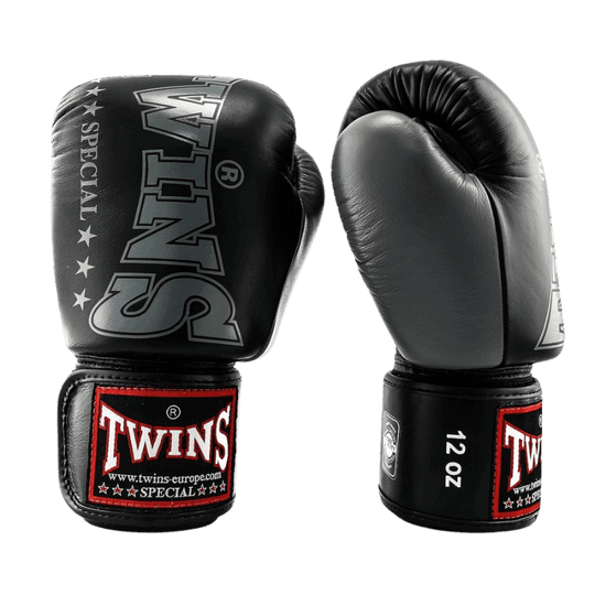 Paar zwarte Twins bokshandschoenen BGVL 8 met een groot wit Twins Special-logo op de rug en rode accenten aan de onderkant van de polsband.
