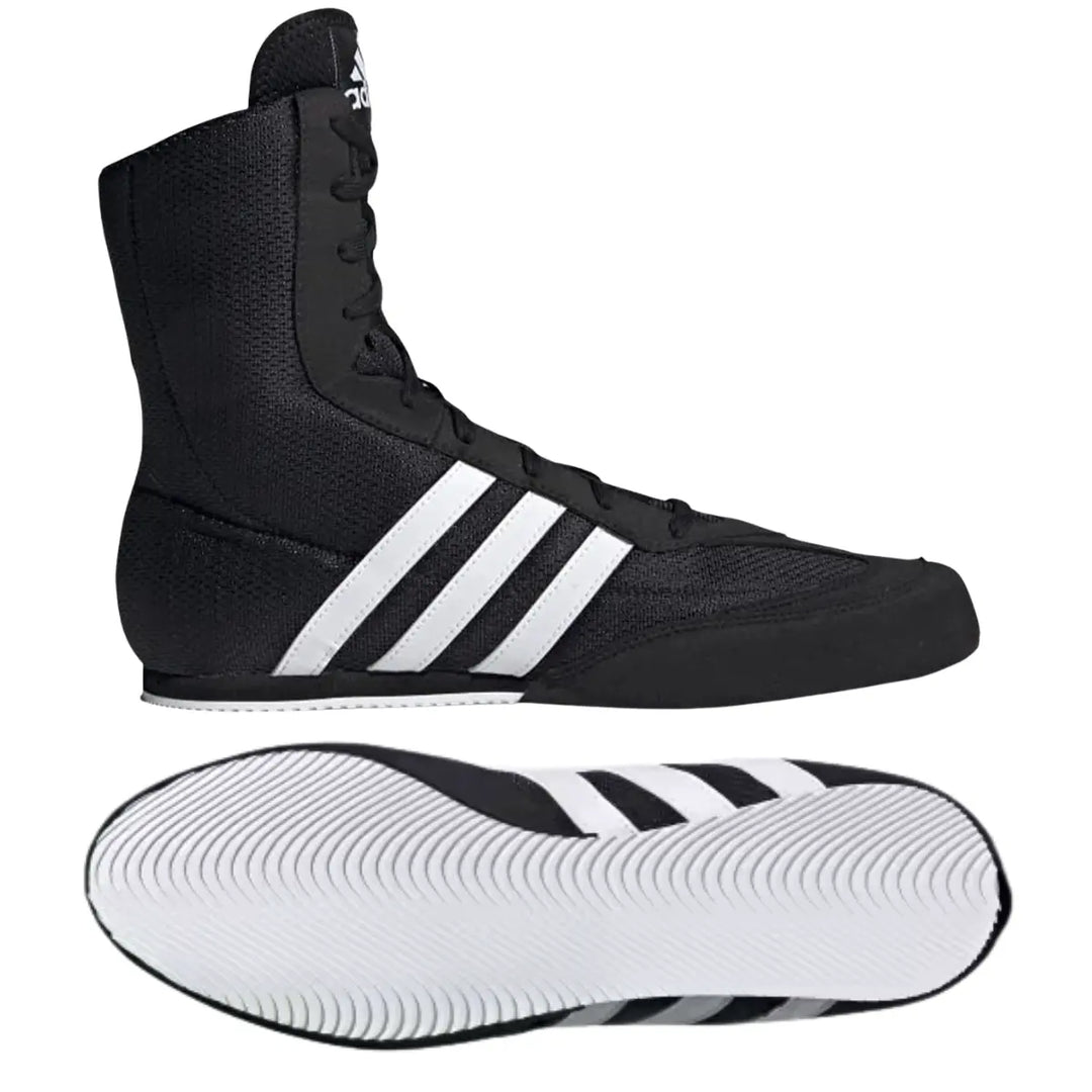 Zwarte Adidas boksschoen met witte drie strepen en hoge vetersluiting, inclusief zicht op de witte zool met gripprofiel.