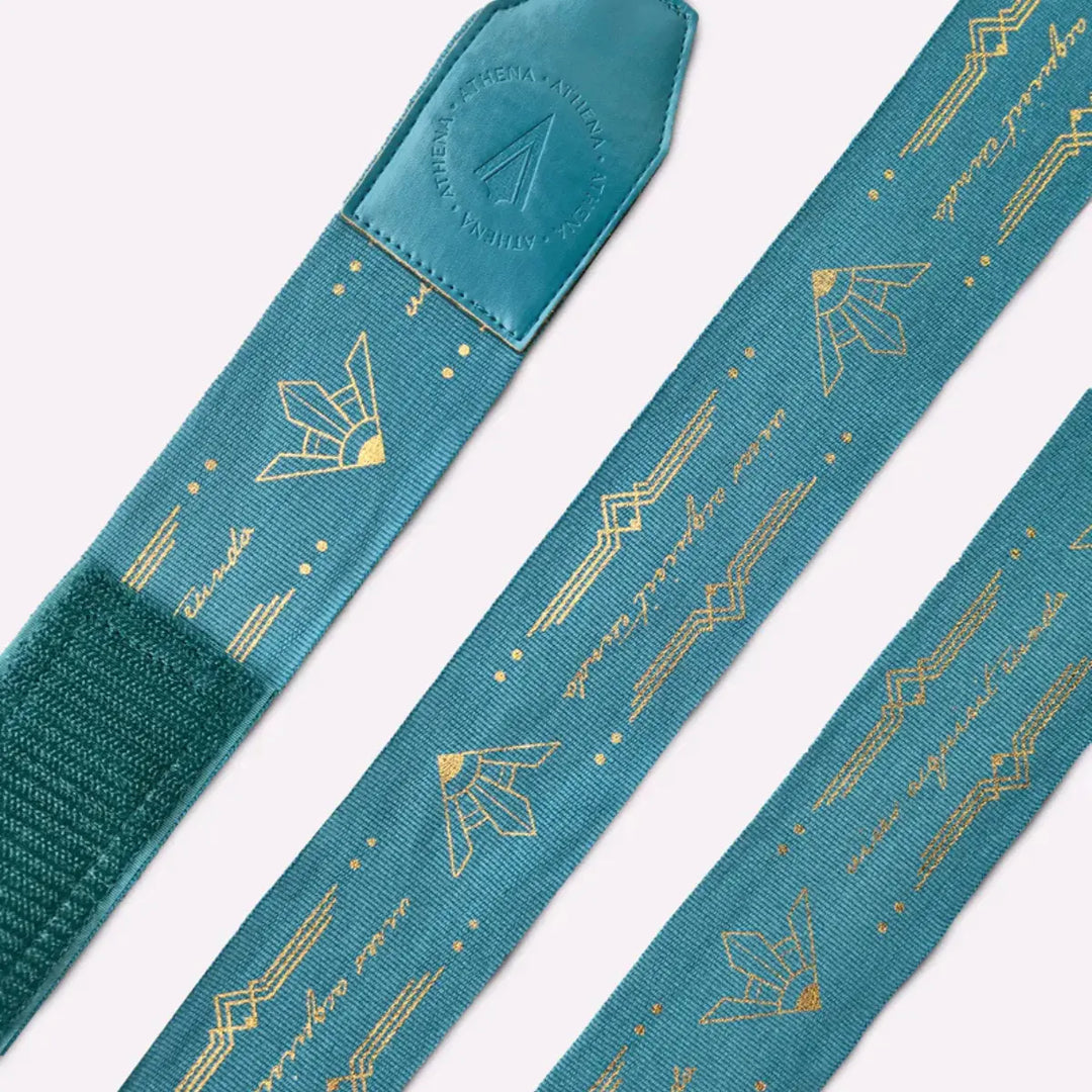 Uitgerolde Athena Fightwear Diana Teal bandages met goud patroon en verstevigde eindstukken voor stevig en comfortabel inwikkelen.