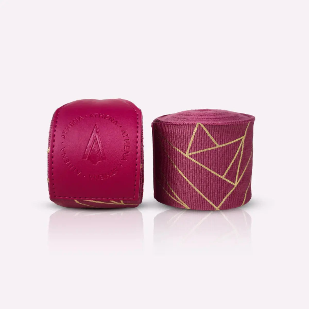 Athena Fightwear Eris Berry handwraps in opgerolde vorm naast de stevige polssluiting. De gouden geometrische lijnen geven de bandages een luxe uitstraling. De foto toont de structuur en kwaliteit van het materiaal duidelijk.