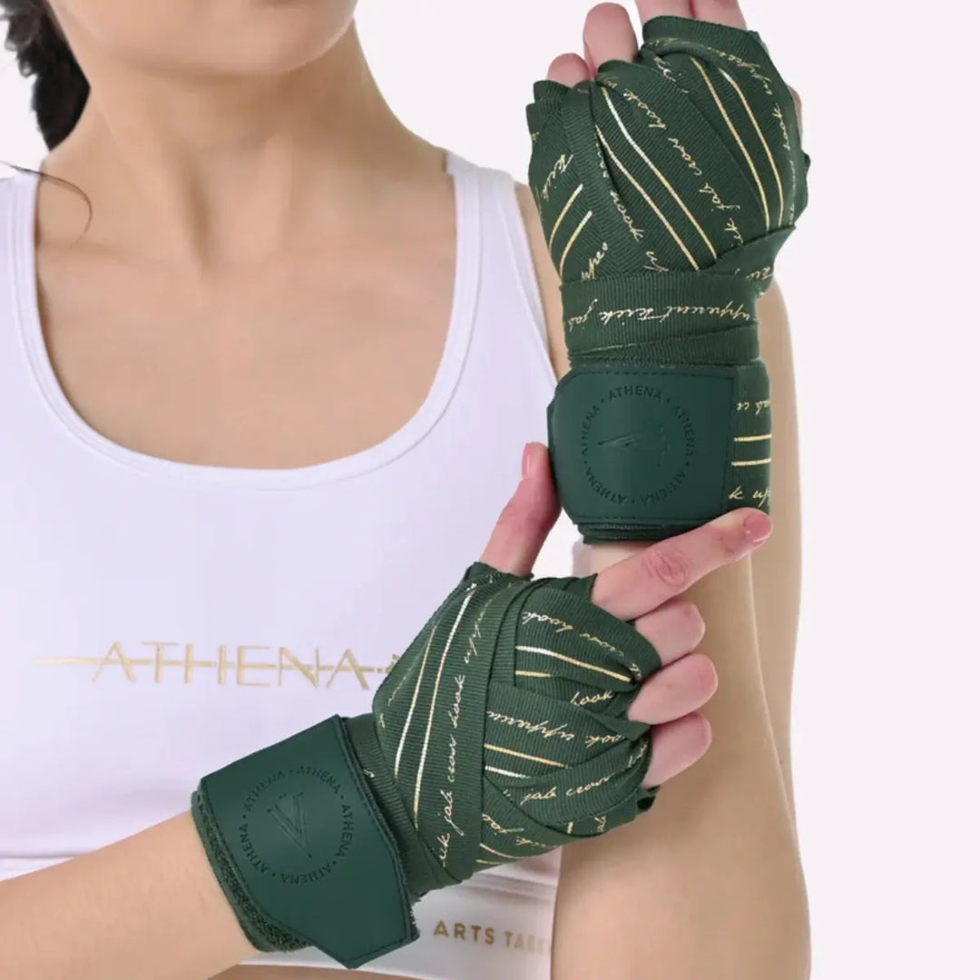 Close-up van Athena Fightwear Nerio Hunter Green bandages om beide handen tijdens training, met goud detailprint.
