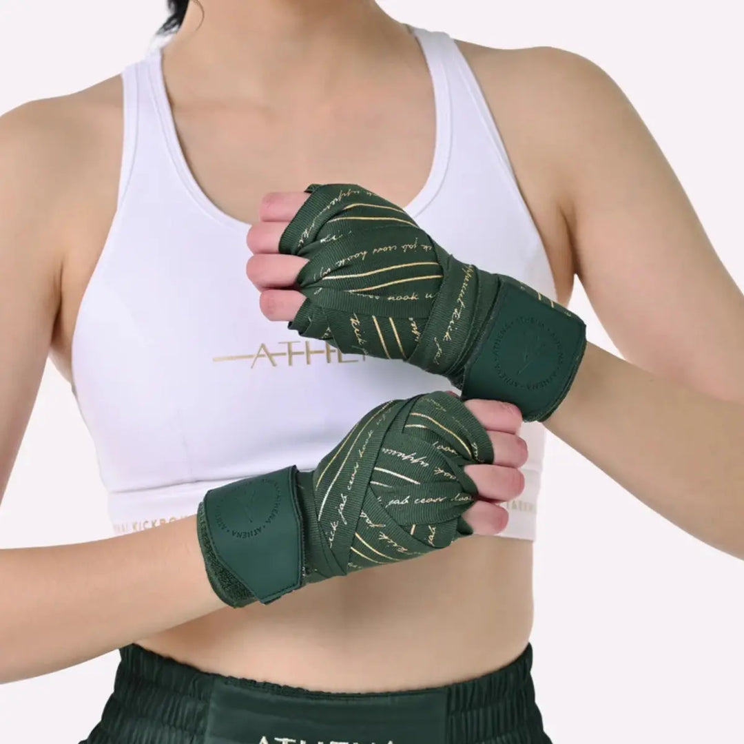 Vrouw draagt Athena Fightwear Nerio Hunter Green bandages, volledig om de handen gewikkeld voor stevige pols- en handondersteuning.