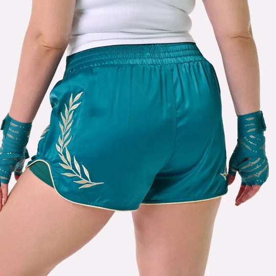 Achterzijde van de Athena Fightwear teal kickboks shorts met gouden lauwerkrans en aansluitende vrouwelijke pasvorm.