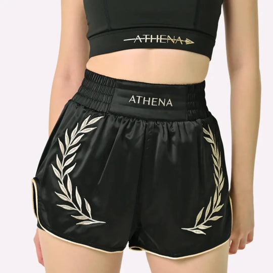 Vooraanzicht van het Athena Fightwear Thaiboks Broekje Zwart Goud met hoge tailleband en gouden details.