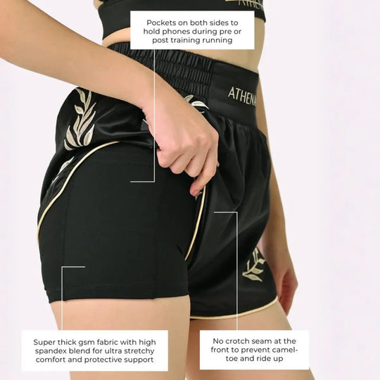 Athena Fightwear Thaiboks Broekje Zwart Goud met zichtbare binnenbroek, telefoonvakjes en naadloos ontwerp aan de voorkant.