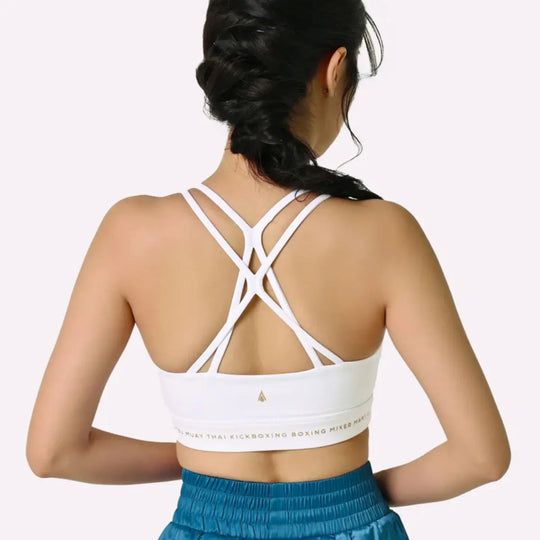 De afbeelding toont de achterkant van de Thessalia sport-BH van Athena Fightwear, met elegante, meerdere gekruiste bandjes en een stevige elastische band onder de borst, gedragen door een vrouwelijke atleet.