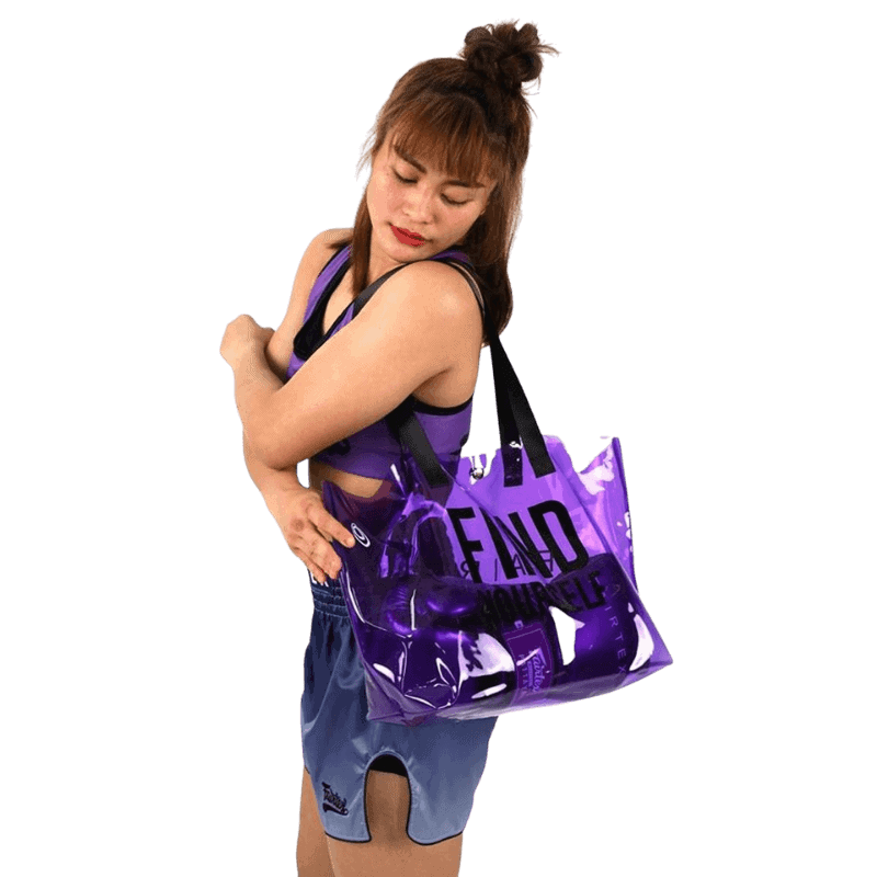 Vrouwelijke atlete die een paarse Fairtex sporttas draagt, passend bij haar handschoenen.