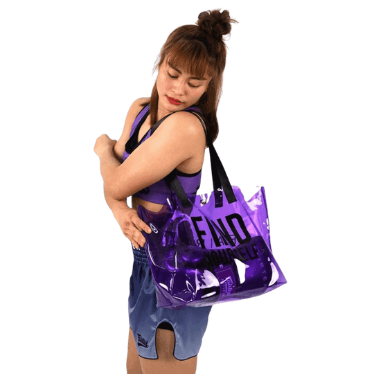 Vrouwelijke atlete die een paarse Fairtex sporttas draagt, passend bij haar handschoenen.
