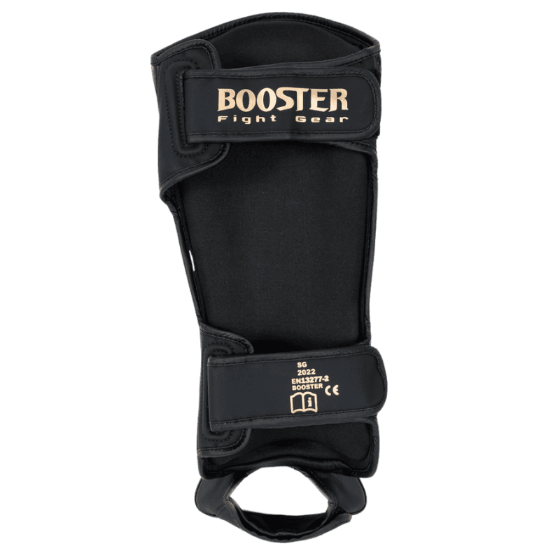 Achteraanzicht van een zwarte Booster scheenbeschermer uit de Bangkok Series, met zwart binnenmateriaal en goudkleurige logo’s op de klittenbandsluitingen.