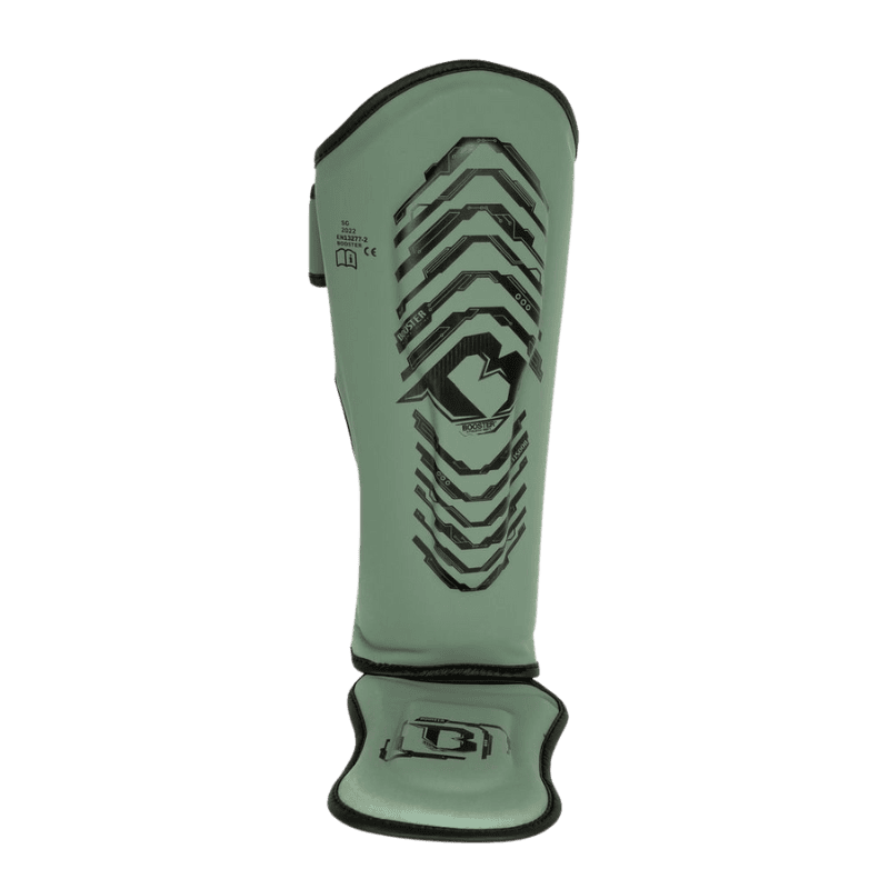 Groene Booster scheenbeschermer met zwart design, vooraanzicht met voetbescherming en een robuuste vorm voor optimale bescherming tijdens training