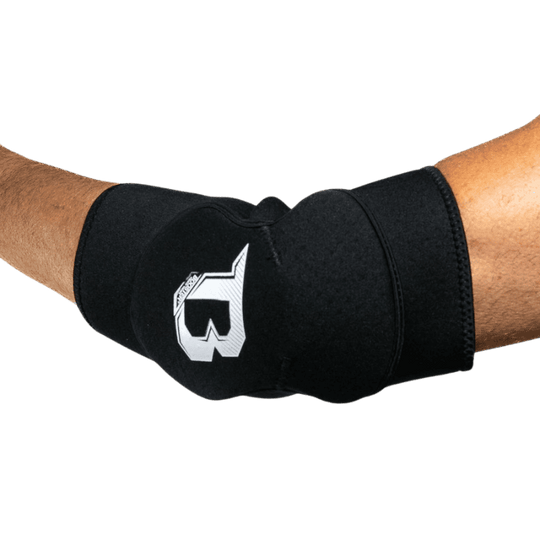 Een arm die een zwarte elleboogbeschermer draagt met een wit logo van het merk Booster aan de buitenkant. De beschermer bedekt de elleboog en biedt duidelijke ondersteuning en bescherming.