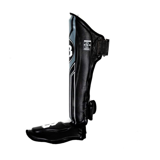 Zijaanzicht van de Booster Scheenbeschermers BSG V9 in zwart met grijze afwerking, met dubbele klittenbandsluiting voor optimale pasvorm en stabiliteit tijdens intensieve kickbokstrainingen.