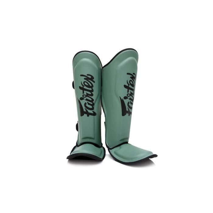 Vooraanzicht van de Fairtex scheenbeschermers in matgroene kleur met zwart logo. De beschermers bieden optimale dekking van scheen en wreef, met stevige padding en verstelbare sluitingen voor comfort en stabiliteit tijdens kickbokstrainingen.
