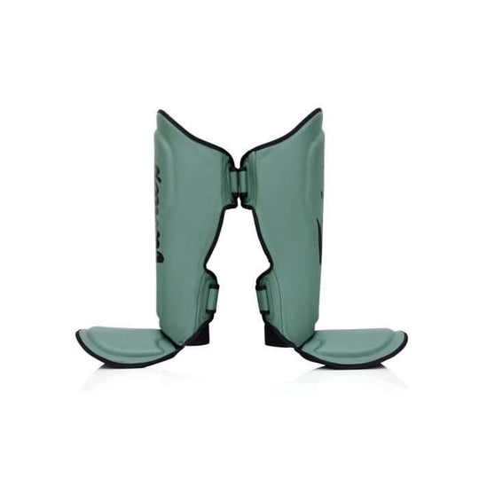 Zijaanzicht van de Booster FXB SG scheenbeschermers in groen. De stevige padding en ergonomische pasvorm zorgen voor maximale bescherming en stabiliteit tijdens intensieve kickbokstrainingen, met dubbele klittenbandsluiting voor een veilige fit.