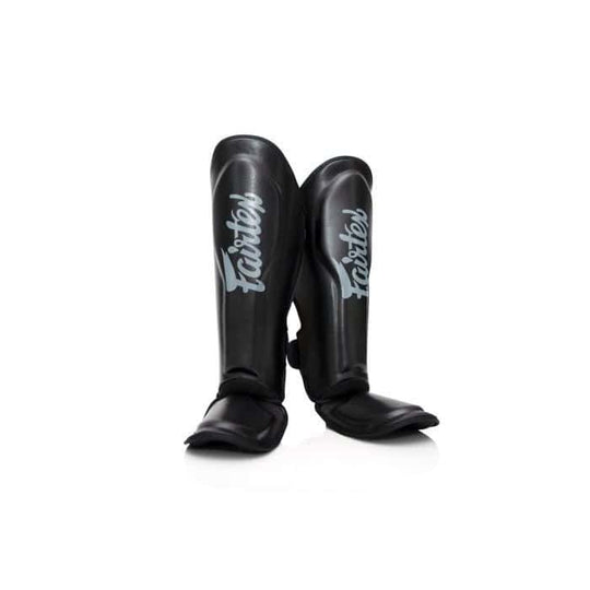 Zwarte Fairtex scheenbeschermers recht van voren gefotografeerd, met zilvergrijze Fairtex-logo’s zichtbaar op beide schenen. Ideaal voor kickboksers die op zoek zijn naar duurzame bescherming en een stijlvolle look.