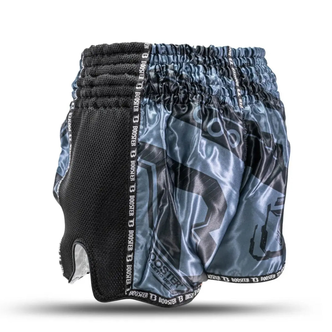 Deze foto toont het broekje vanaf de rechterkant, waar de combinatie van satijn en mesh goed zichtbaar is. De Booster-branding loopt subtiel langs de randen. De diepe split aan de zijkant bevordert bewegingsvrijheid tijdens trappen en knie-technieken.