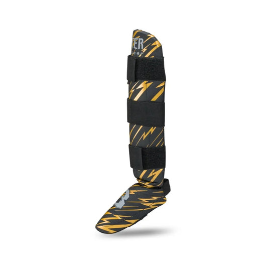 Booster Fight Gear scheenbeschermer voor kids, met opvallend goud/zwart design en drie verstelbare klittenbandsluitingen voor stevige pasvorm.









