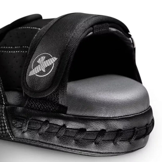 Close-up van een zwarte Hayabusa bokspad met stevige zwarte stiknaden, een comfortabele grip en een verstelbare klittenbandsluiting met het Hayabusa-logo voor optimale training en controle.