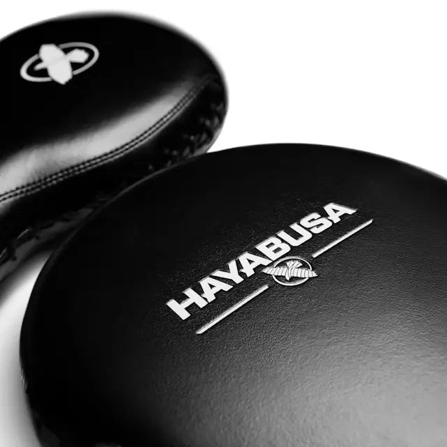 Close-up van twee zwarte bokspads met het witte Hayabusa-logo en de vogel.