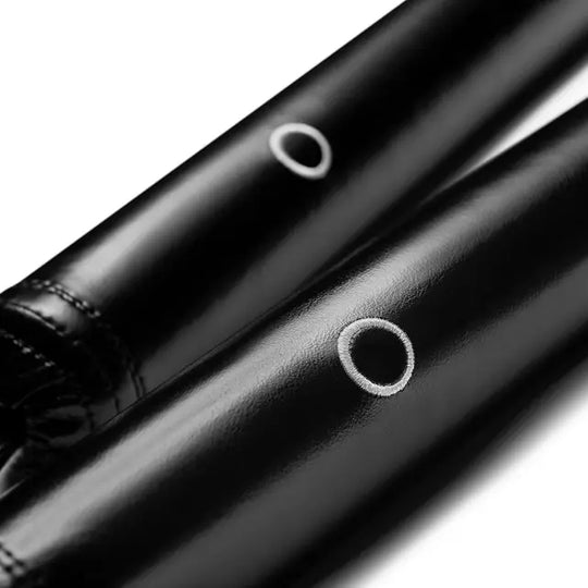 : Twee zwarte trainingssticks met witte cirkelvormige markeringen, scherp gefotografeerd op een witte achtergrond.