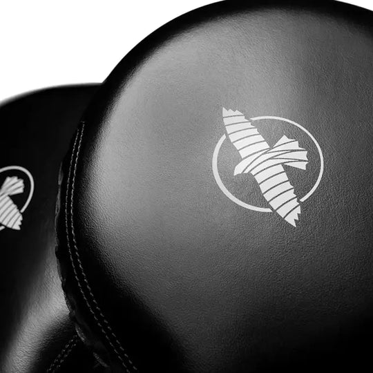 Close-up van zwarte bokspads met het witte Hayabusa-logo en gestileerde vogel op het leer.
