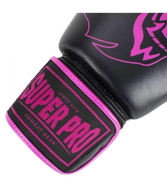 Close-up van de zwarte polssluiting van een bokshandschoen, met het roze Super Pro Combat Gear logo en roze stiksel.