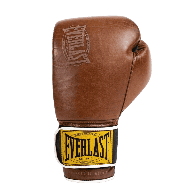 Afbeelding van een bruine Everlast 1910 Classic Training bokshandschoen, gezien van de zijkant. De handschoen heeft een klassieke leren buitenkant met een subtiel gestanst Everlast-logo. De zwarte polsband is voorzien van het iconische gele Everlast-logo met witte randafwerking, wat een vintage uitstraling geeft. Het ontwerp straalt authenticiteit en duurzaamheid uit, ideaal voor training en sparren.