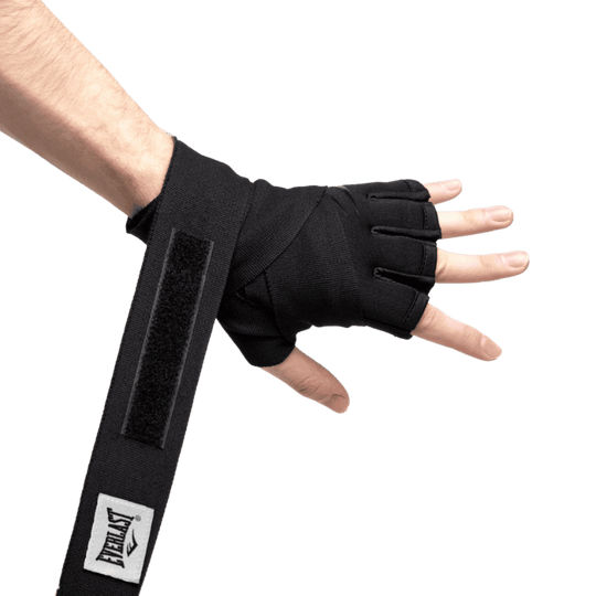 Close-up van een hand met een Everlast Fastwraps Evergel zwarte bandage, waarbij de duim en vingers gespreid zijn. De bandage is gedeeltelijk om de pols gewikkeld en de klittenbandsluiting is zichtbaar