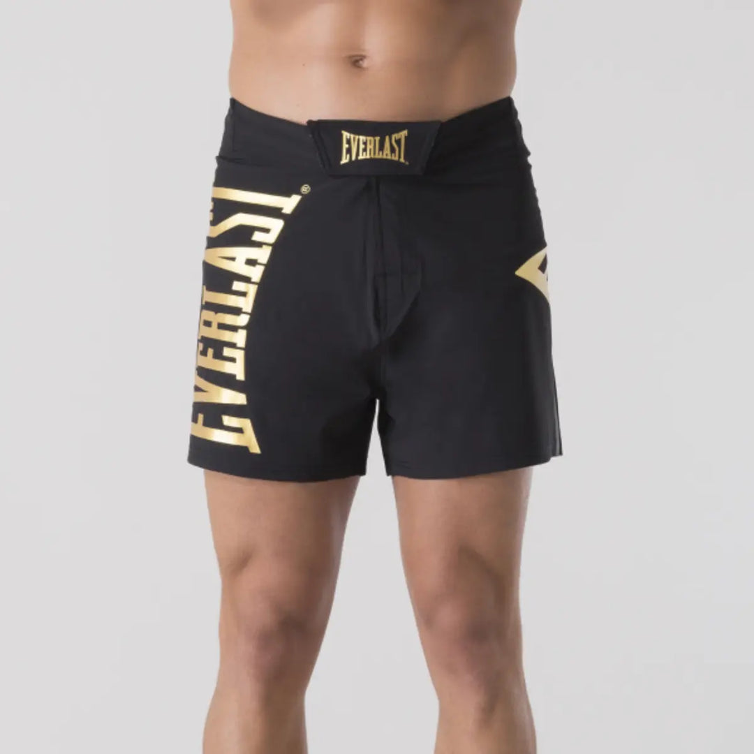Vooraanzicht van zwart Everlast MMA broekje met groot goudkleurig Everlast logo en verstelbare tailleband.